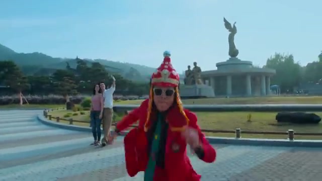 청와대 앞에서 붉은 의상의 무용수가 카메라를 향해 다가오는 장면